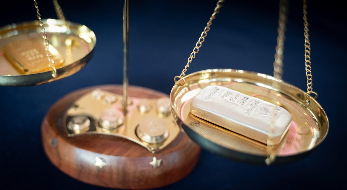 Gold and silver bars on a set of brass scales